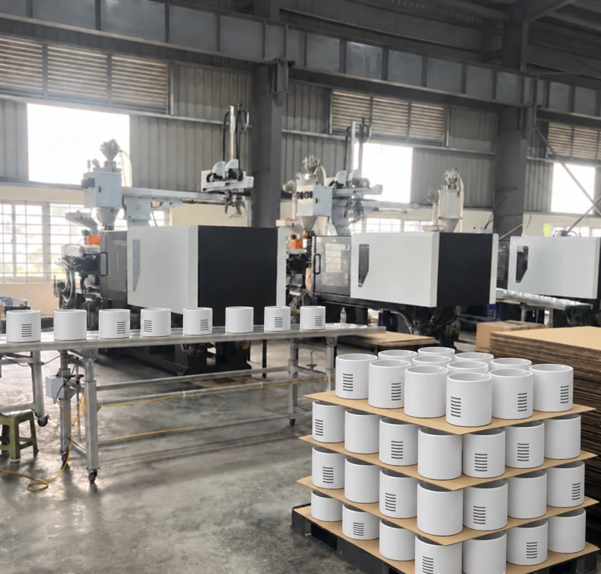 AI-edited photograph: White air purifier housings beside injection molding presses