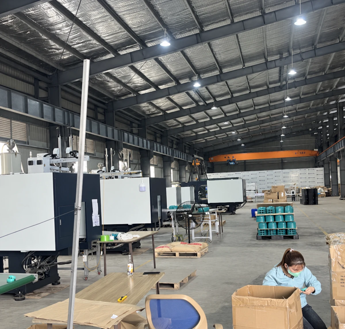 AI-enhanced photograph: Factory floor with workers and parts undergoing production and packing